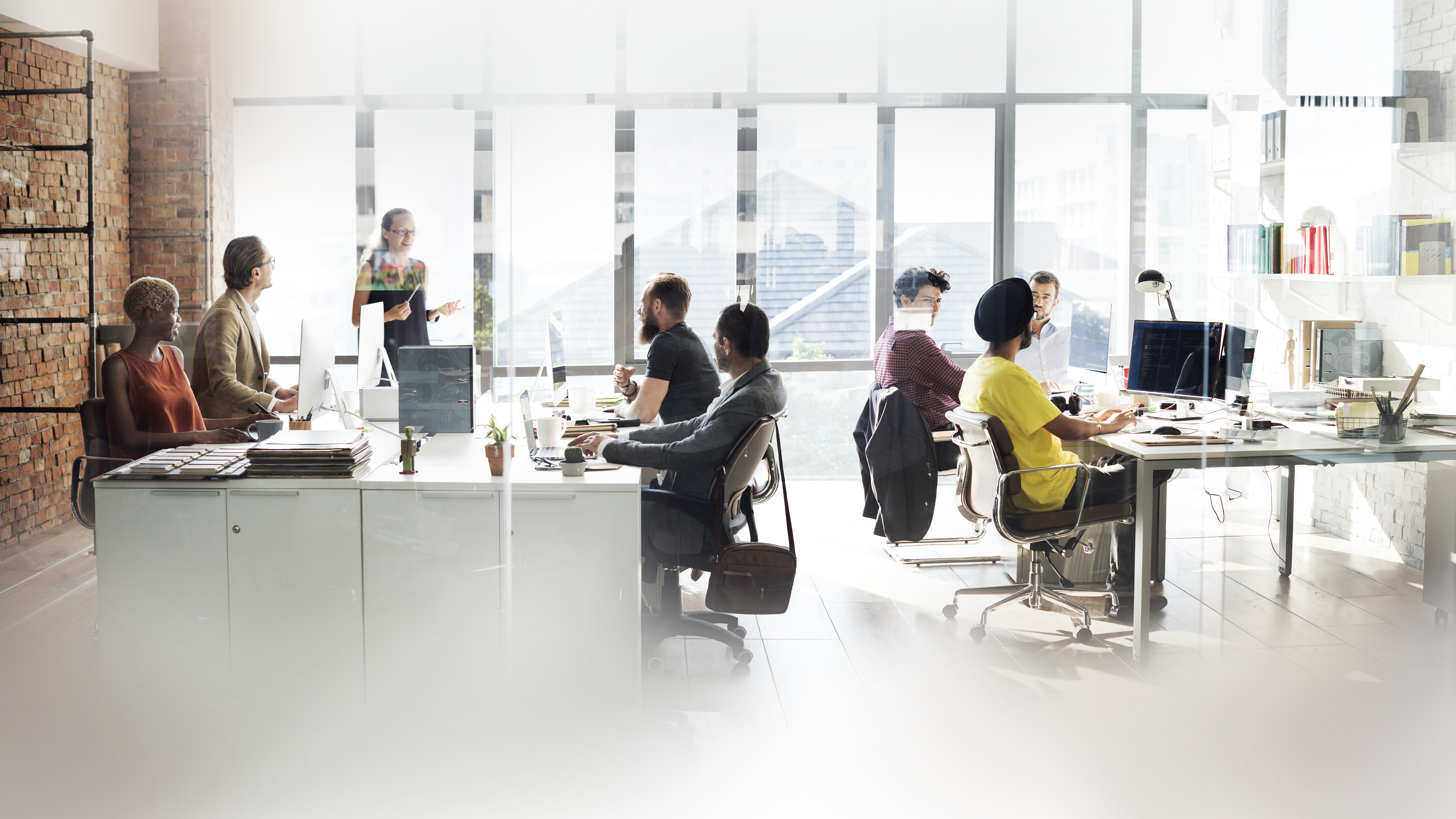 Modern open-plan coworking office with professionals collaborating at shared desks